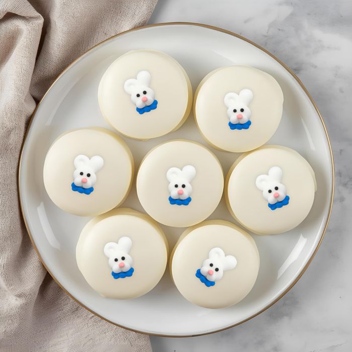 Chocolate covered oreo cookies decorated with mini pastel Easter Bunny Face royal icing toppers