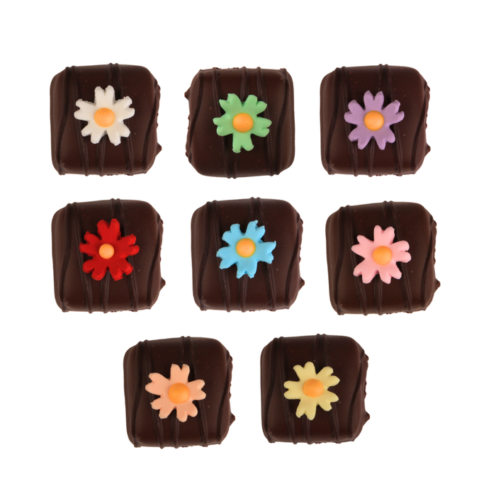 Close-up detail of edible fuchsia sugar flowers with realistic petals and assorted vibrant colors