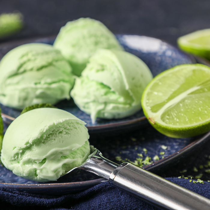 Pastel green key lime soft-serve ice cream swirl served on a crispy waffle cone.