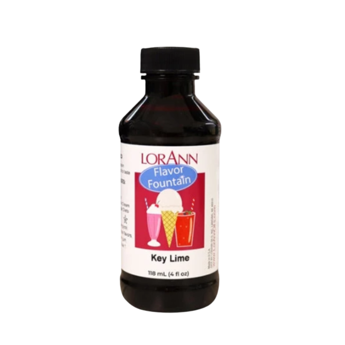 4 oz bottle of LorAnn Key Lime ice cream and beverage flavor extract next to fresh key limes and lime juice.
