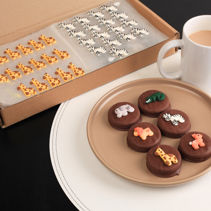 Safari themed zoo animal icing toppers including lion, elephant, giraffe and zebra used to decorate cupcakes, cookies and small party desserts by Caljava.