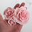 Hand holding three handcrafted pink sugar garden roses showing assorted size comparison and petal details by Caljava