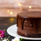 Melting Amoretti rich chocolate fudge ganache poured over a multi-layer cake as a high-gloss glaze