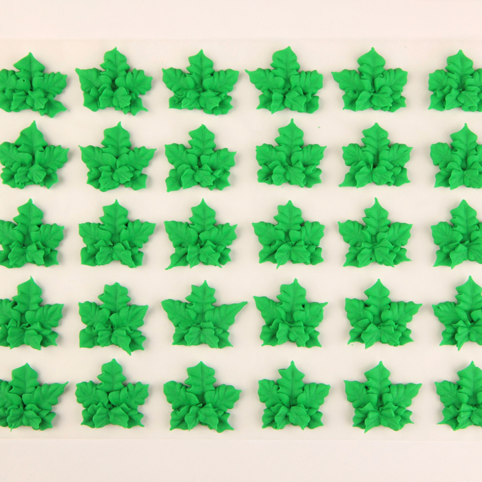 Dispensary bakery infused cupcakes finished with hand-piped green cannabis leaf royal icing decorations.
