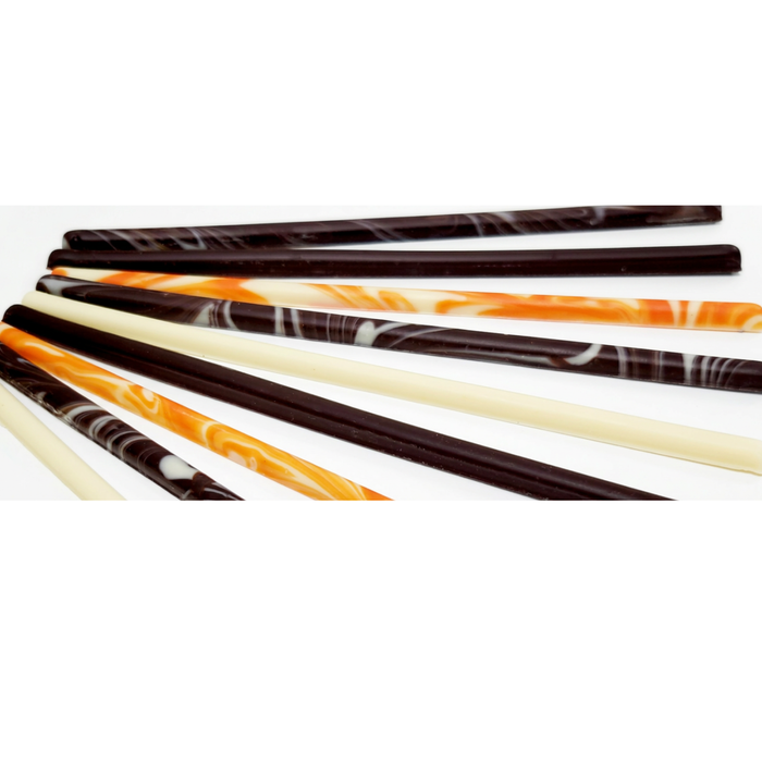 French entremet cake decorated with elegant white and dark chocolate garnish sticks.