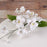 Close-up of handcrafted white gumpaste Singapore orchid blooms showing intricate petals and realistic details by Caljava.