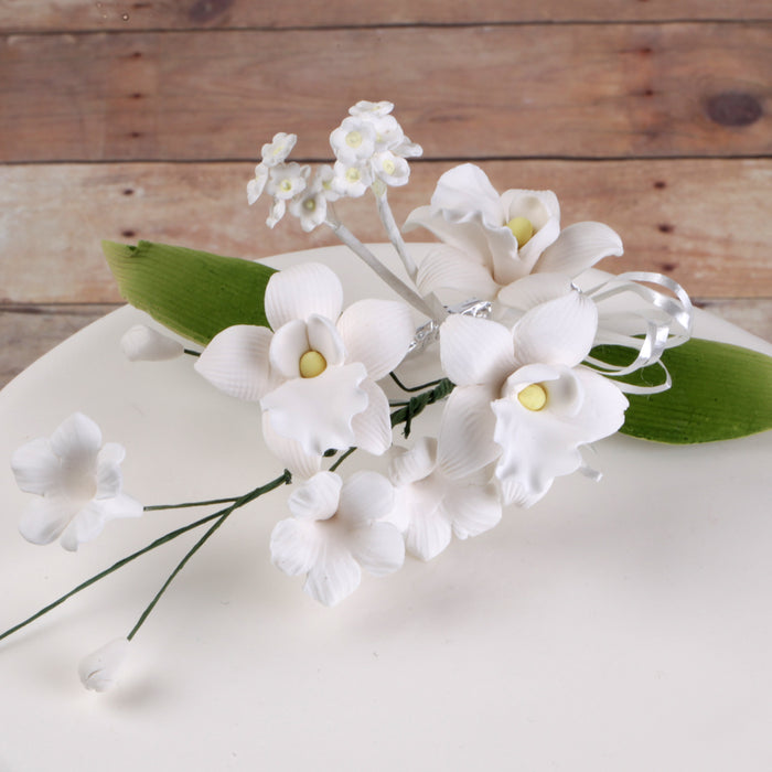 Close-up of handcrafted white gumpaste Singapore orchid blooms showing intricate petals and realistic details by Caljava.
