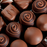Pouring tempered Blommer Marquette Gold dark chocolate into polycarbonate candy molds for artisan bonbons.