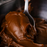 Piping creamy Amoretti chocolate fudge ganache filling onto gourmet chocolate cupcakes and tarts