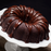 Piping creamy Amoretti chocolate fudge ganache filling onto gourmet chocolate bundt cakes