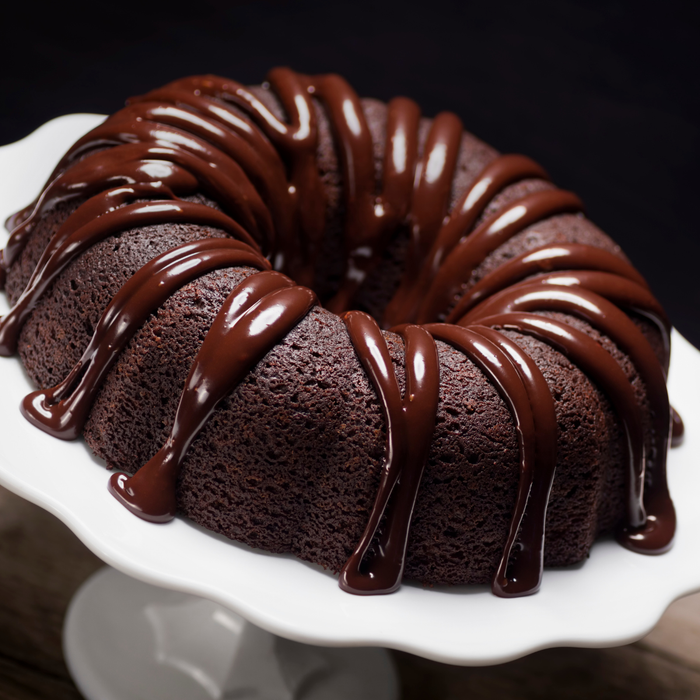 Piping creamy Amoretti chocolate fudge ganache filling onto gourmet chocolate bundt cakes