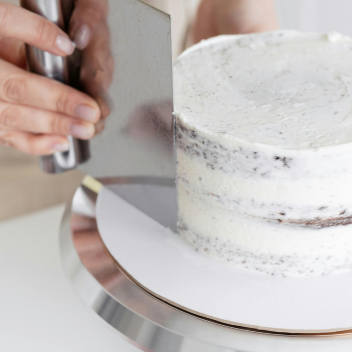 Decorating a gourmet cupcake with a rich piping swirl of pre-whipped white buttercream icing