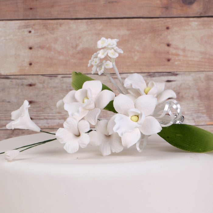 Pre-wired flexible stem on a white gumpaste orchid spray cake topper for easy cake placement.