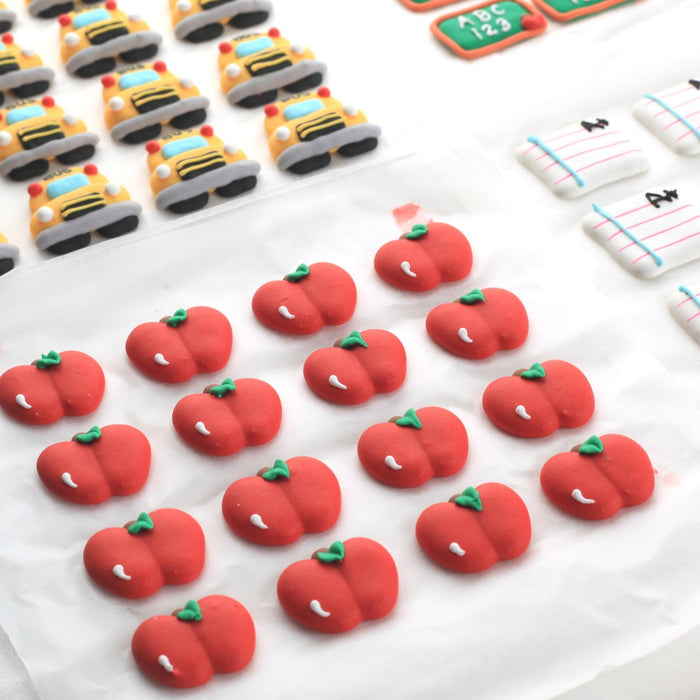 Artisanal dark chocolate bark pieces topped with colorful edible sugar decorations for holiday gifts.