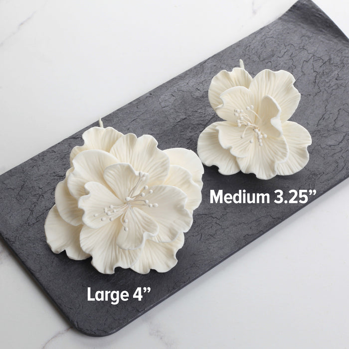 Premade large white Cora peony sugar flower placed on a modern rustic buttercream cake.
