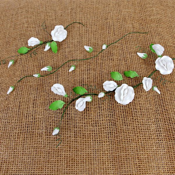 Three different sizes of long stem white sweet pea sugar flower fillers arranged for tiered cake decorating.