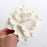Close-up of a handcrafted 4-inch white Cora peony sugar flower showing detailed textured petals. Caljava