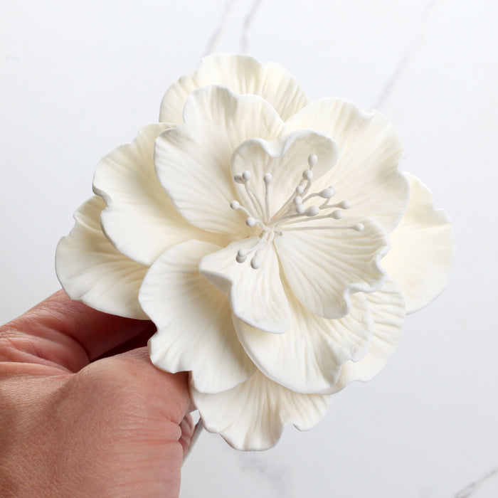 Close-up of a handcrafted 4-inch white Cora peony sugar flower showing detailed textured petals. Caljava