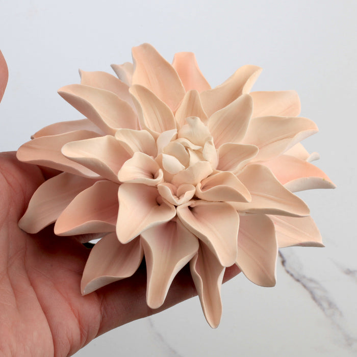 Close-up view of a realistic peach gumpaste dahlia flower featuring detailed handcrafted petals and a flexible wired stem.Wholesale sugarflower. Caljava Bakery Supplies