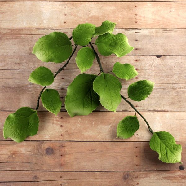 Close-up of pre-wired green sugar leaves showing the flexible wired stems for secure, effortless cake insertion