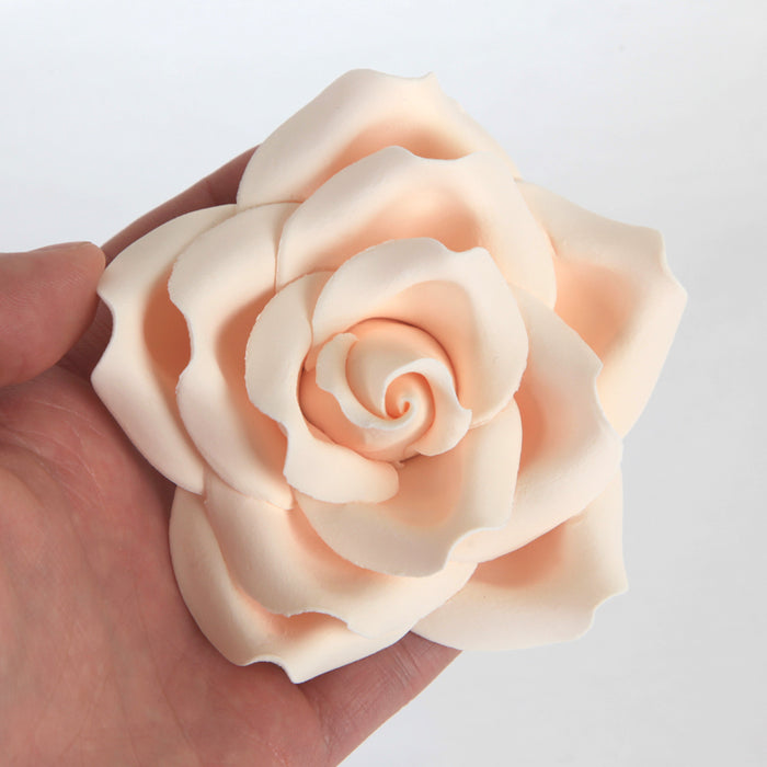 Close-up of a pre-wired ivory gumpaste garden rose showcasing its flexible wire stem for easy placement.