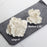 Handcrafted white Cora peony sugar flowers decorating a multi-tiered wedding cake.