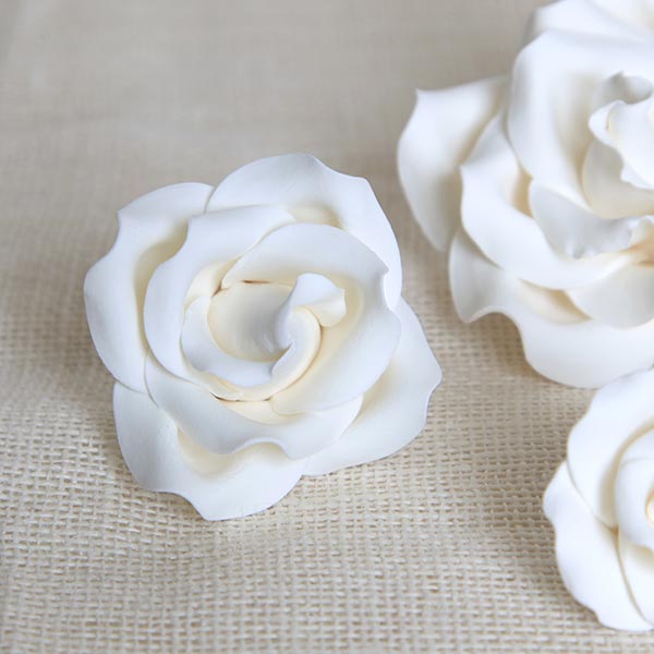 Pre-made white sugar flower cake decorations used by commercial bakeries to improve kitchen efficiency